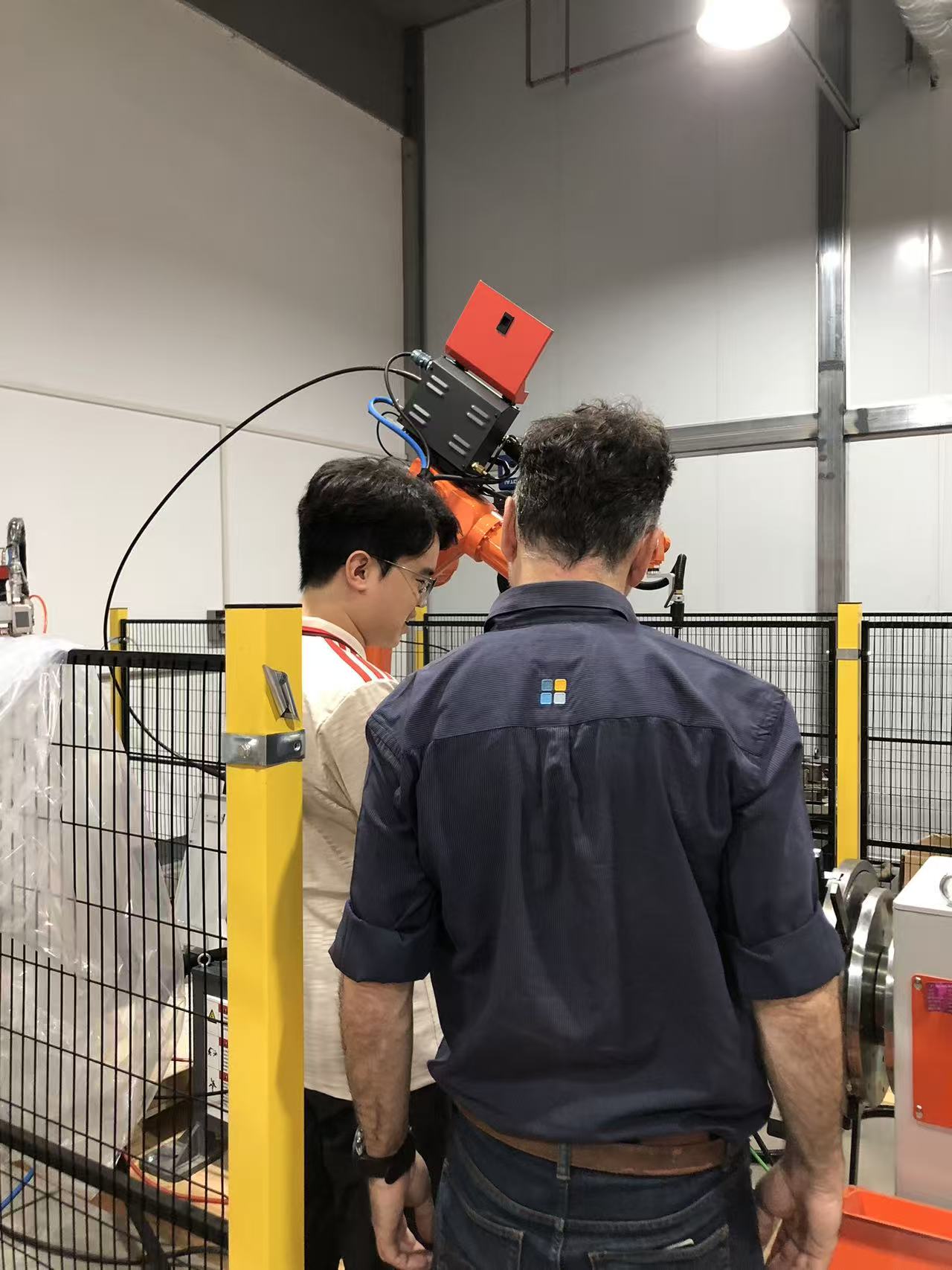 SZGH engineer explains welding robot programming and workflow to the visiting team.jpg